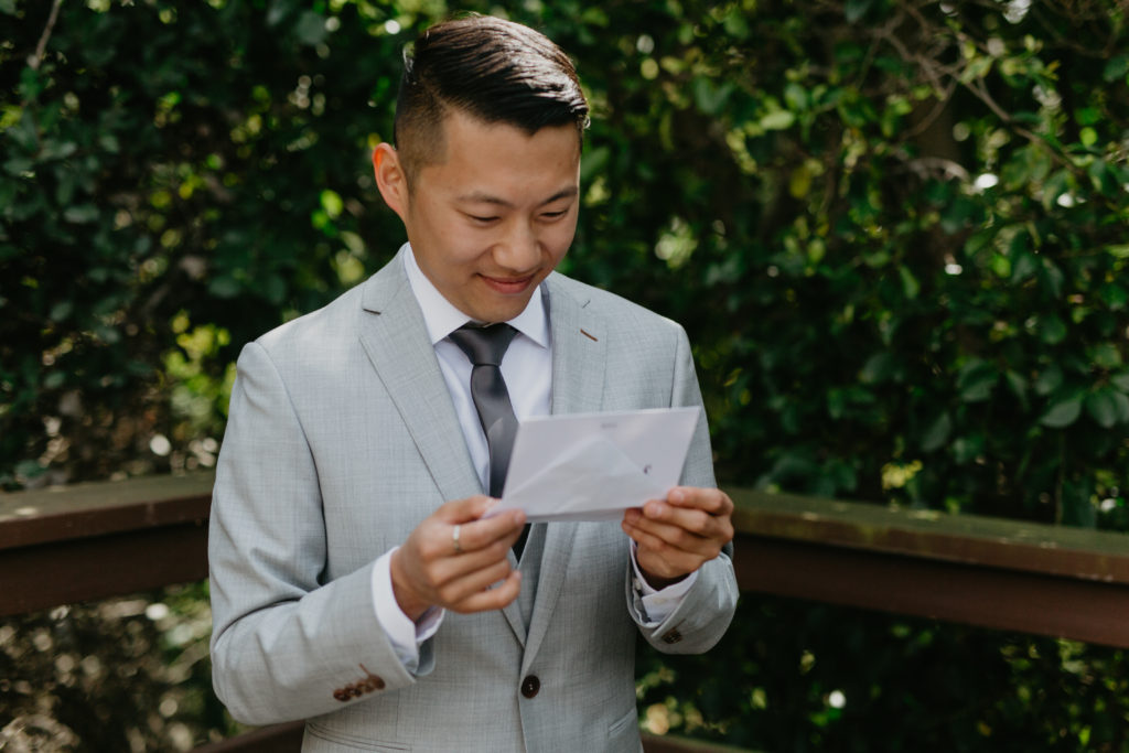 A music festival themed wedding at The Inn at Rancho Santa Fe, groom reading letter from bride
