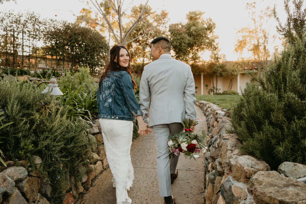 A music festival themed wedding at The Inn at Rancho Santa Fe, bride and groom portrait shot, bride wearing custom just married jean jacket