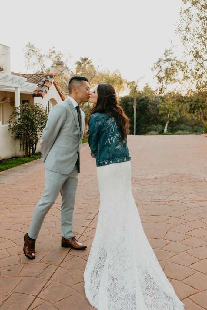 A music festival themed wedding at The Inn at Rancho Santa Fe, bride and groom portrait shot, bride wearing custom just married jean jacket