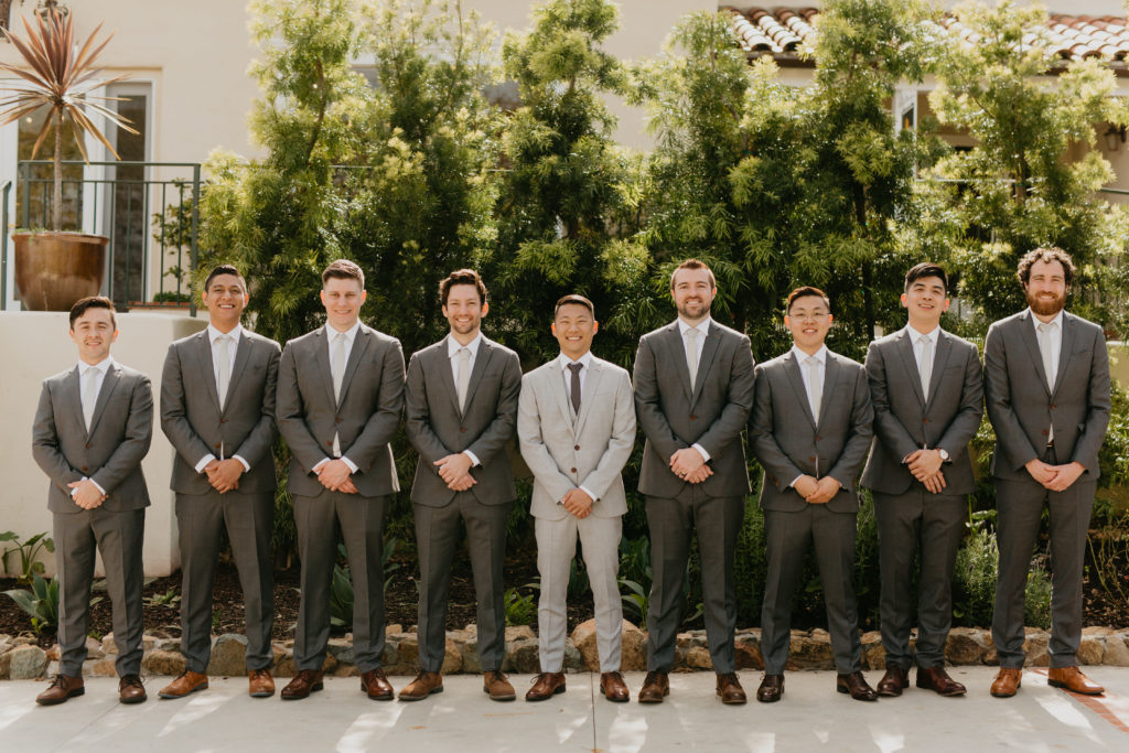 A music festival themed wedding at The Inn at Rancho Santa Fe, wedding party portrait shots, groomsmen in dark grey suits