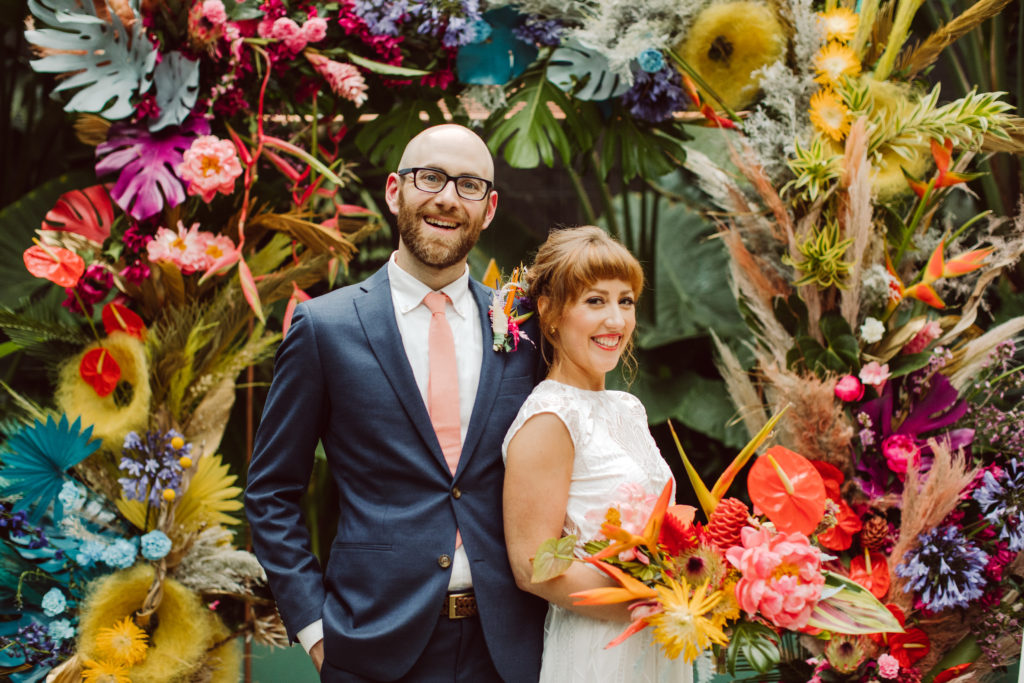 A unique and colorful wedding at the Grass Room in downtown Los Angeles, bride and groom portrait shot with rainbow inspired chuppah