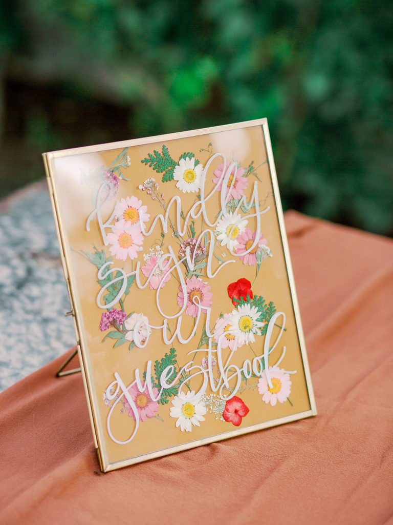 A colorful and vibrant wedding ceremony at Triunfo Creek Vineyards, floral welcome sign