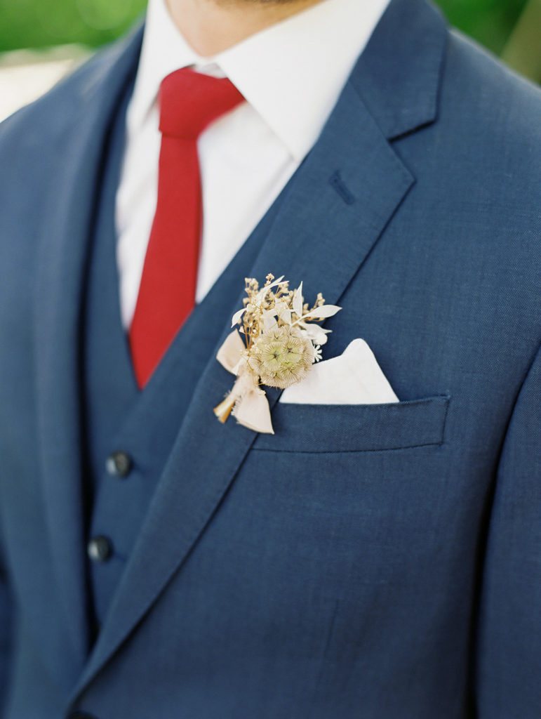 A colorful and vibrant wedding at Triunfo Creek Vineyards, soft and romantic groom boutonniere