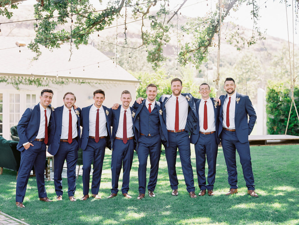 A colorful and vibrant wedding at Triunfo Creek Vineyards, groom and groomsmen in navy suits and red ties