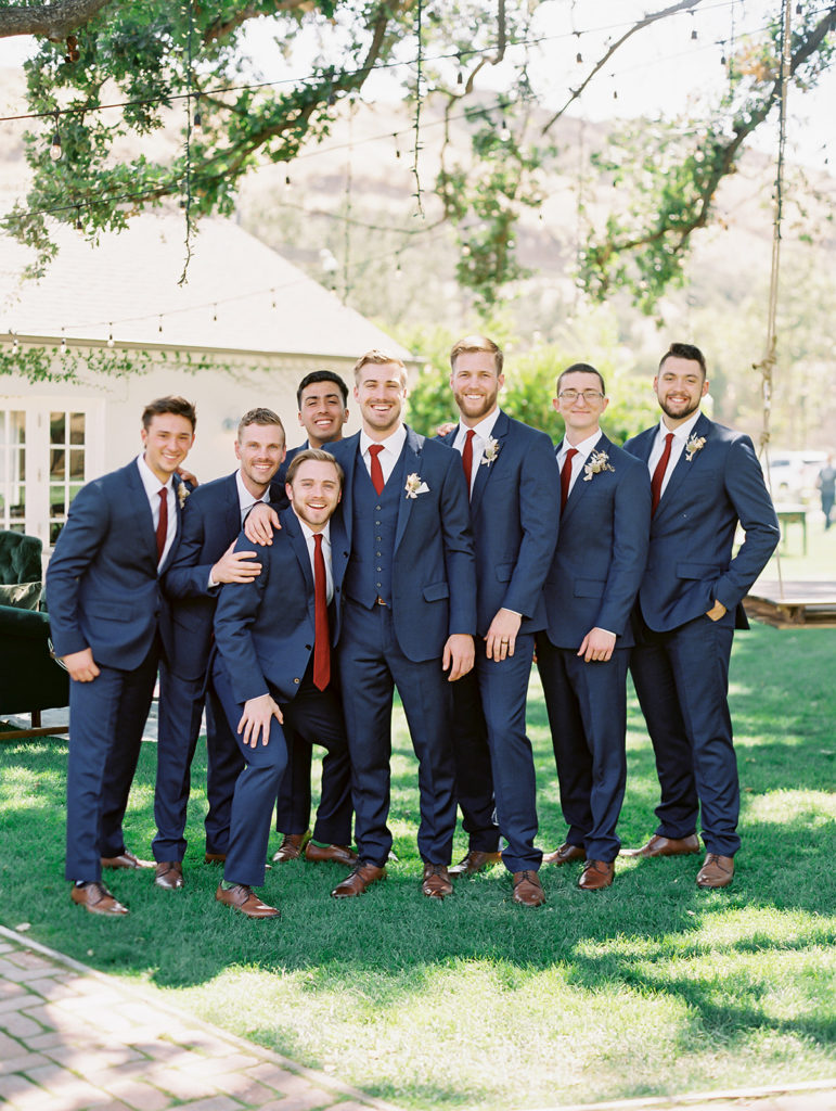 A colorful and vibrant wedding at Triunfo Creek Vineyards, groom and groomsmen in navy suits and red ties
