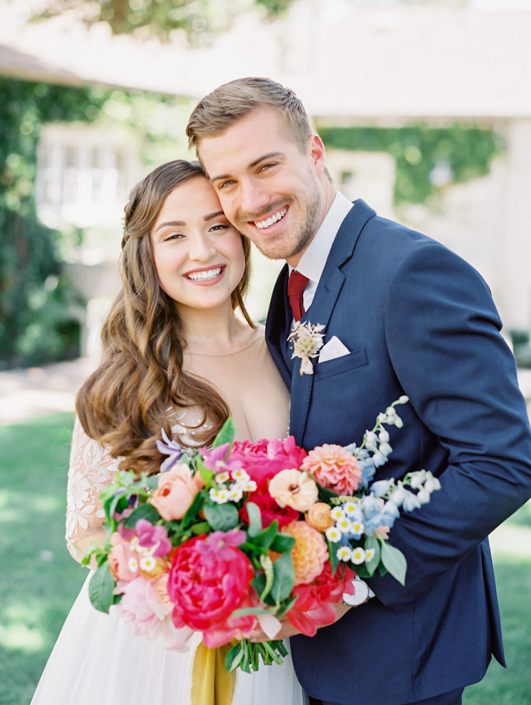 A colorful and vibrant wedding at Triunfo Creek Vineyards, bride and groom portrait shot, bright and colorful bridal bouquet with yellow ribbon