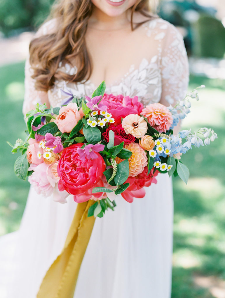 A colorful and vibrant wedding at Triunfo Creek Vineyards, bride portrait shot, bright and colorful bridal bouquet with yellow ribbon