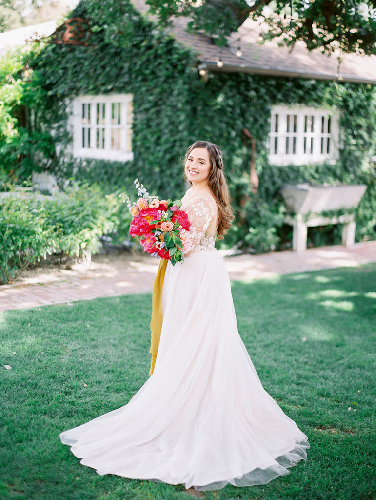 A colorful and vibrant wedding at Triunfo Creek Vineyards, bride portrait shot, bright and colorful bridal bouquet with yellow ribbon