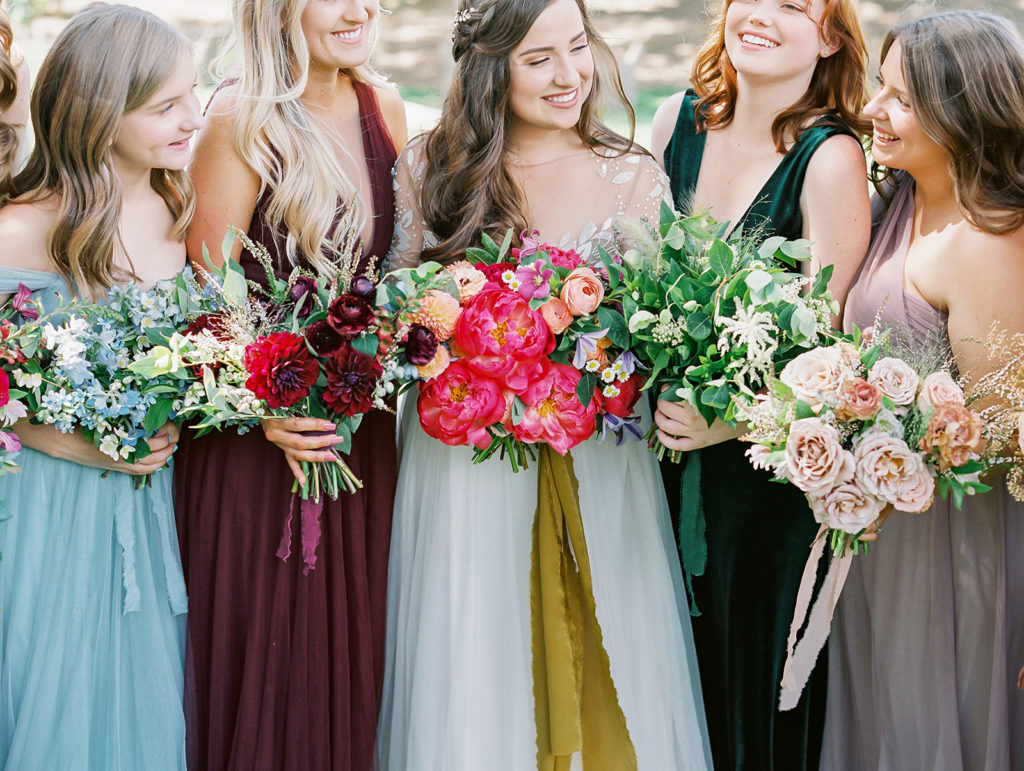A colorful and vibrant wedding at Triunfo Creek Vineyards, bride and bridesmaids in mix matching colorful dresses and bouquets