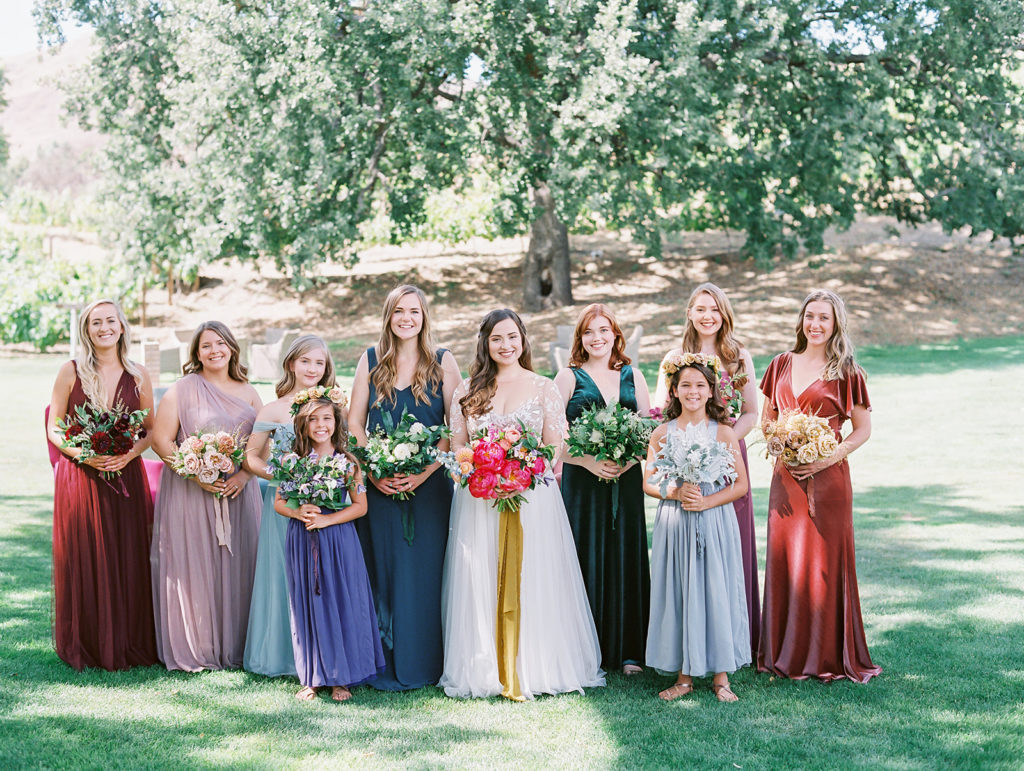 A colorful and vibrant wedding at Triunfo Creek Vineyards, bride and bridesmaids in mix matching colorful dresses and bouquets