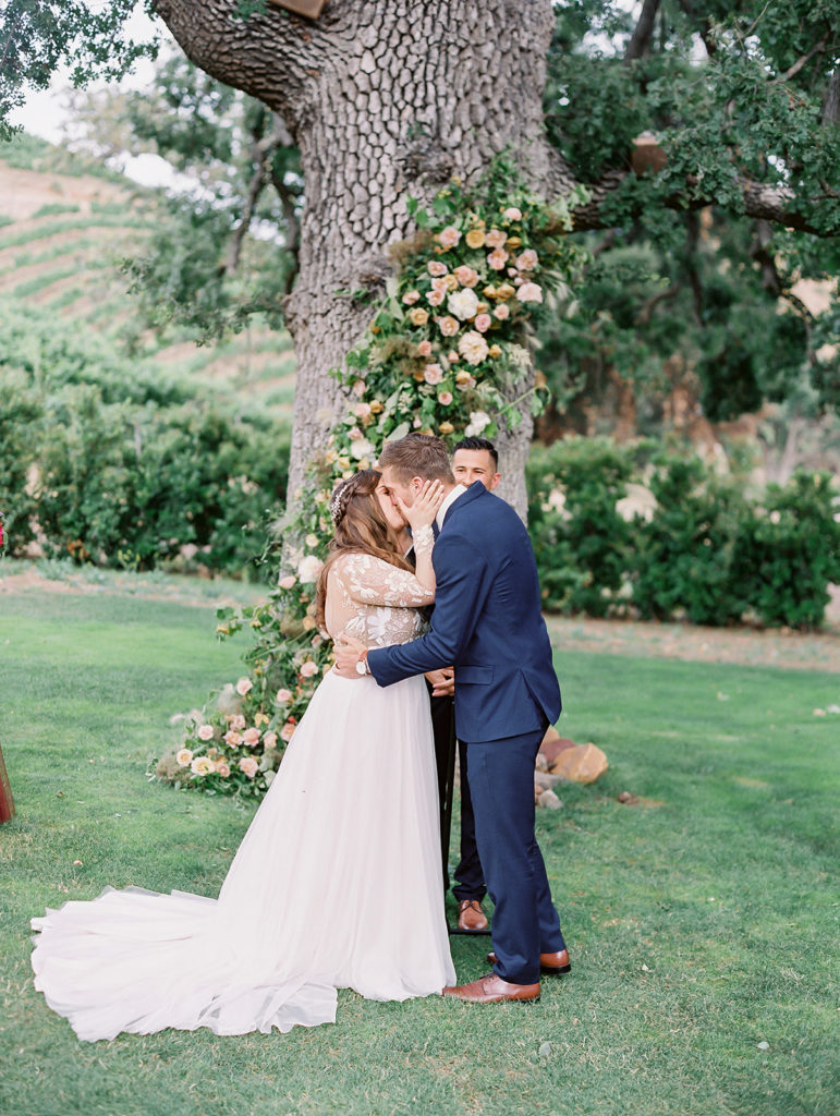 A colorful and vibrant wedding ceremony at Triunfo Creek Vineyards, first kiss