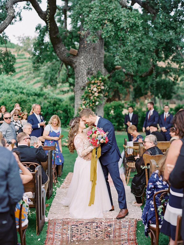 A colorful and vibrant wedding ceremony at Triunfo Creek Vineyards, bride and groom