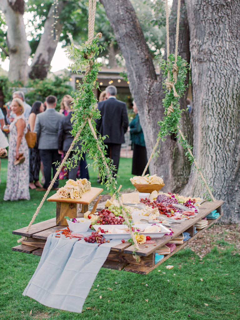 A colorful and vibrant wedding reception at Triunfo Creek Vineyards, cocktail hour hanging charcuterie board