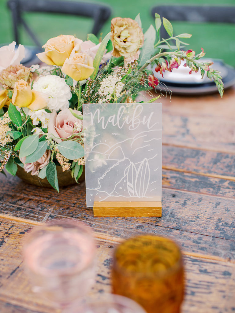 A colorful and vibrant wedding reception at Triunfo Creek Vineyards, city as table number
