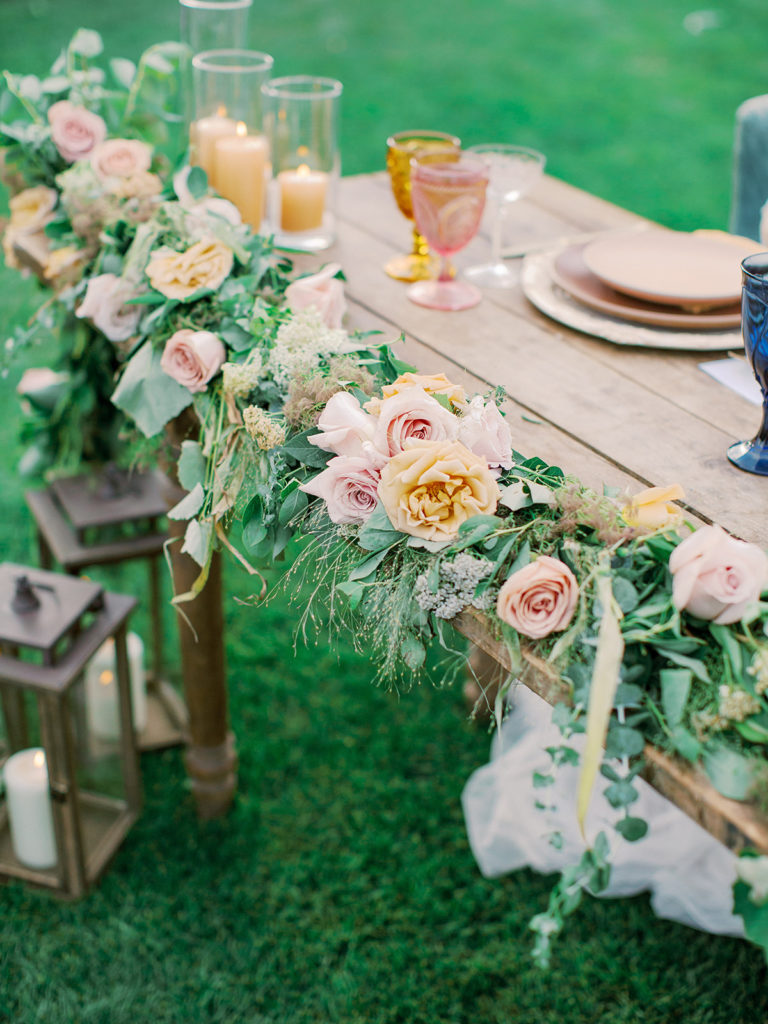 A colorful and vibrant wedding reception at Triunfo Creek Vineyards, sweetheart table garland