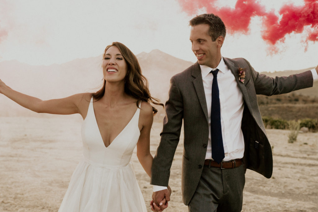 A whimsical wedding at Triunfo Creek Vineyards, sunset bride and groom portrait with smoke bombs