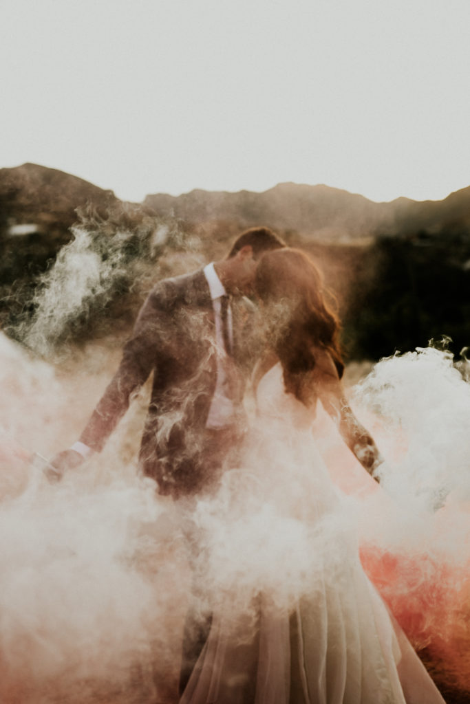 A whimsical wedding at Triunfo Creek Vineyards, sunset bride and groom portrait with colored smoke bombs
