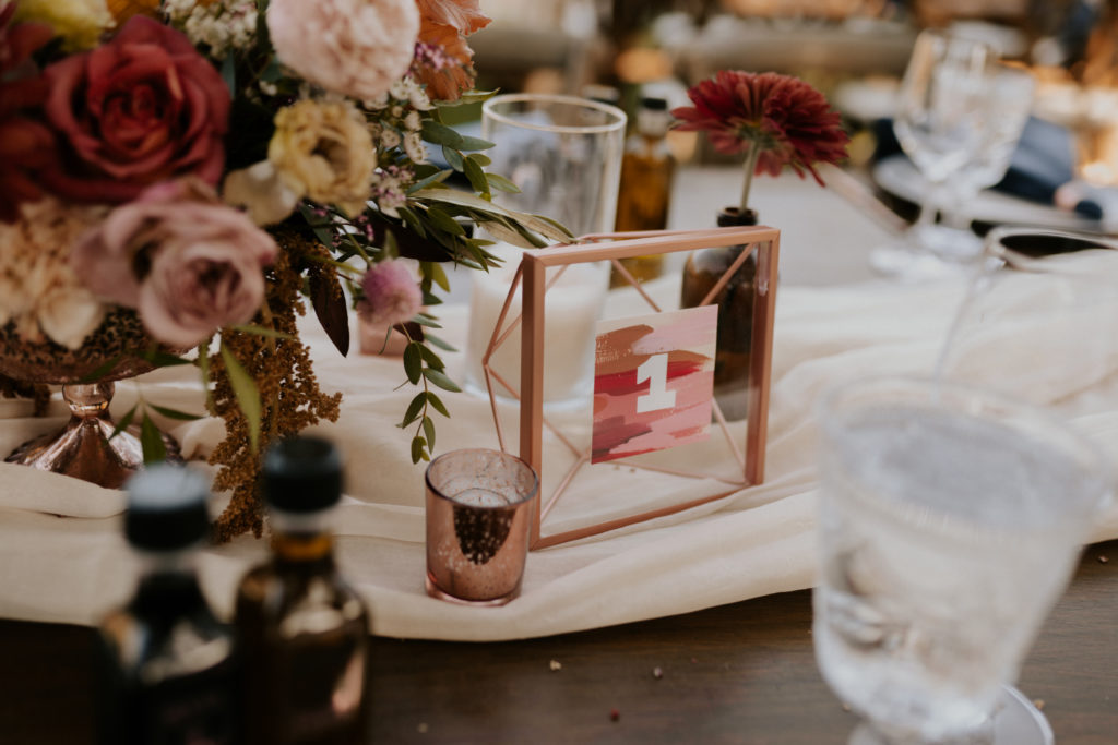 A whimsical wedding reception at Triunfo Creek Vineyards, pink and orange table number