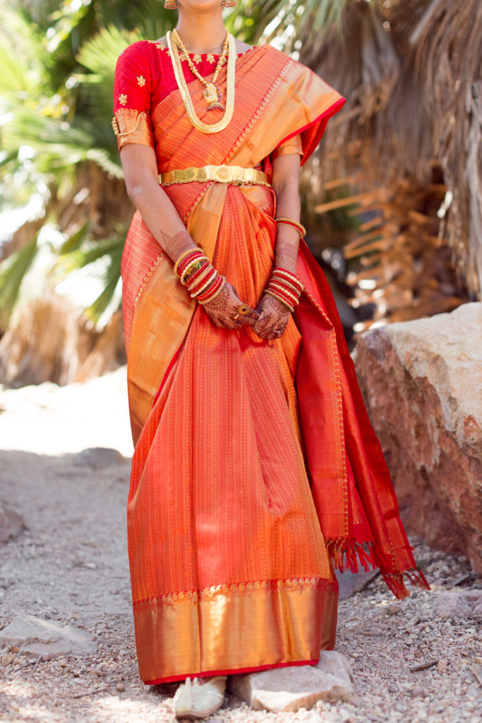 Bridal portrait shot with bride wearing red and orange wedding saree