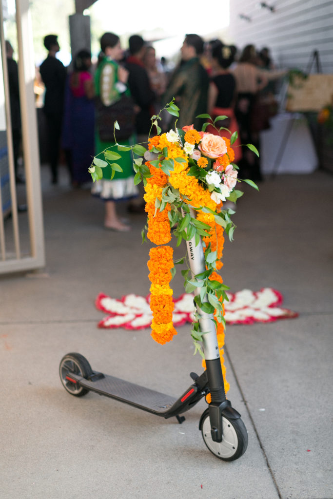 groom riding floral covered scooter for traditional Indian baraat