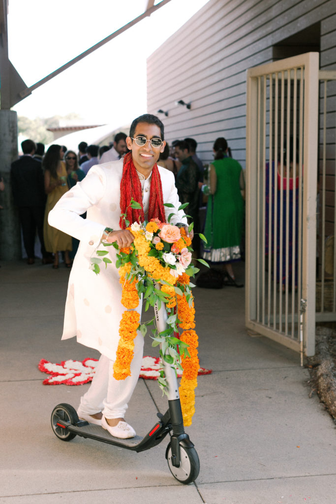 groom riding floral covered scooter for traditional Indian baraat