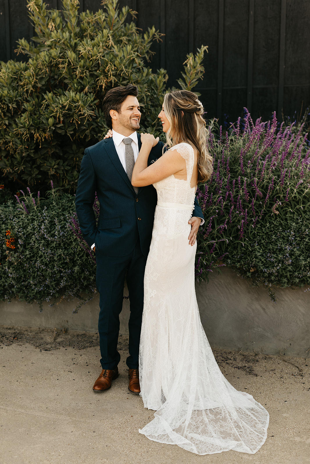 bride in lace dress with groom in dark blue suit portrait shot at Roblar Winery