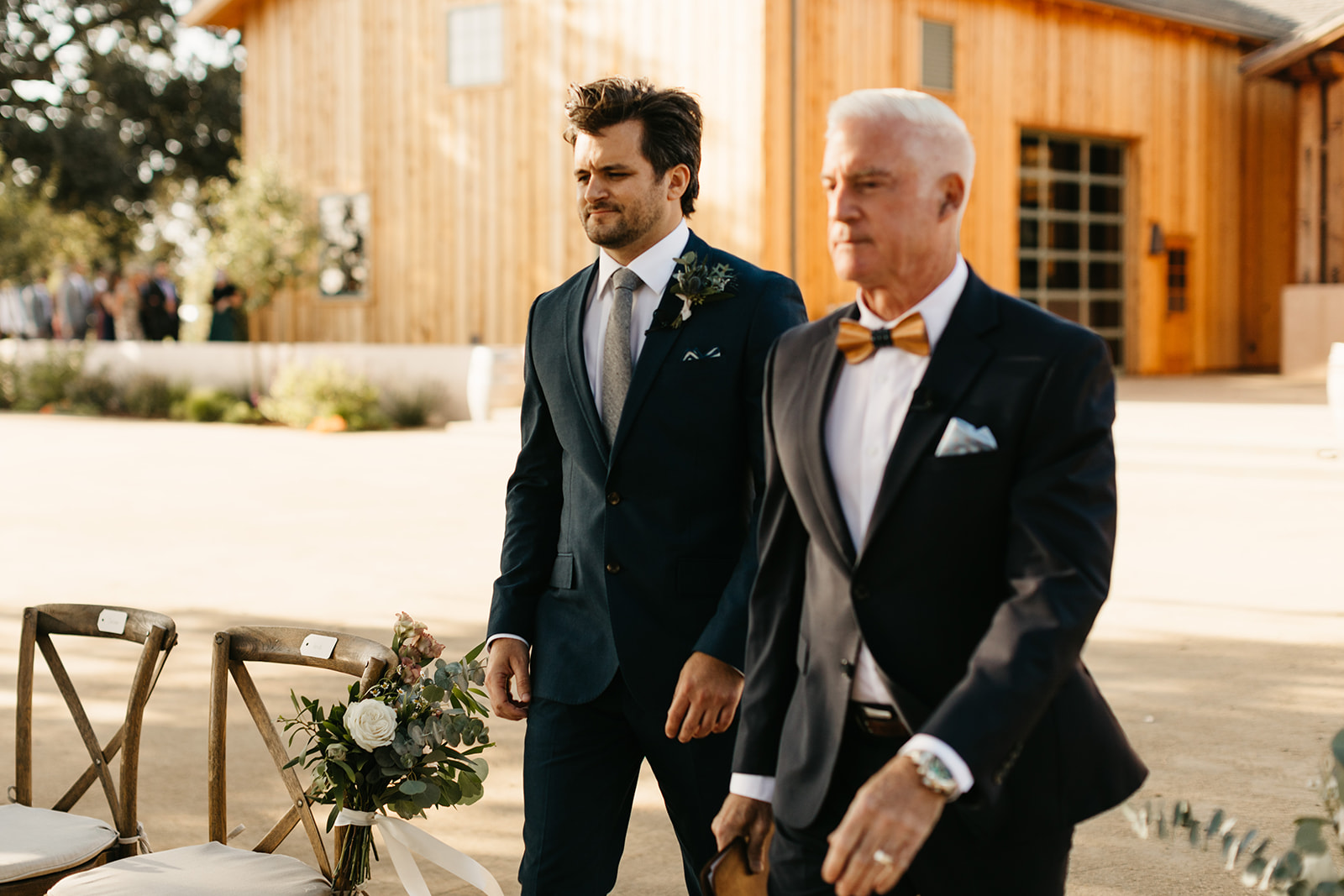 groom walking down aisle with officiant for wedding