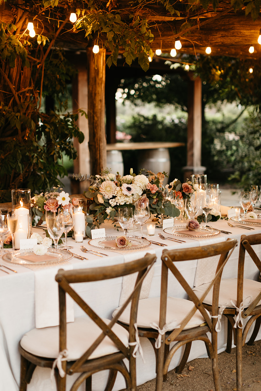 Intimate vineyard wedding reception at Roblar winery under market lights with blush pink and greenery