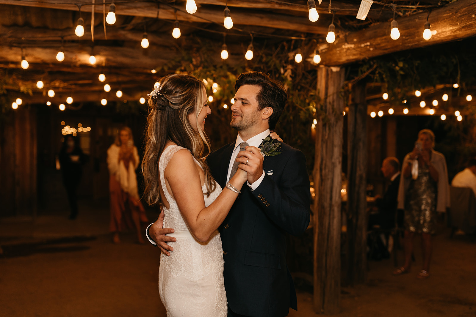 couple first dance under market lights at Roblar Winery