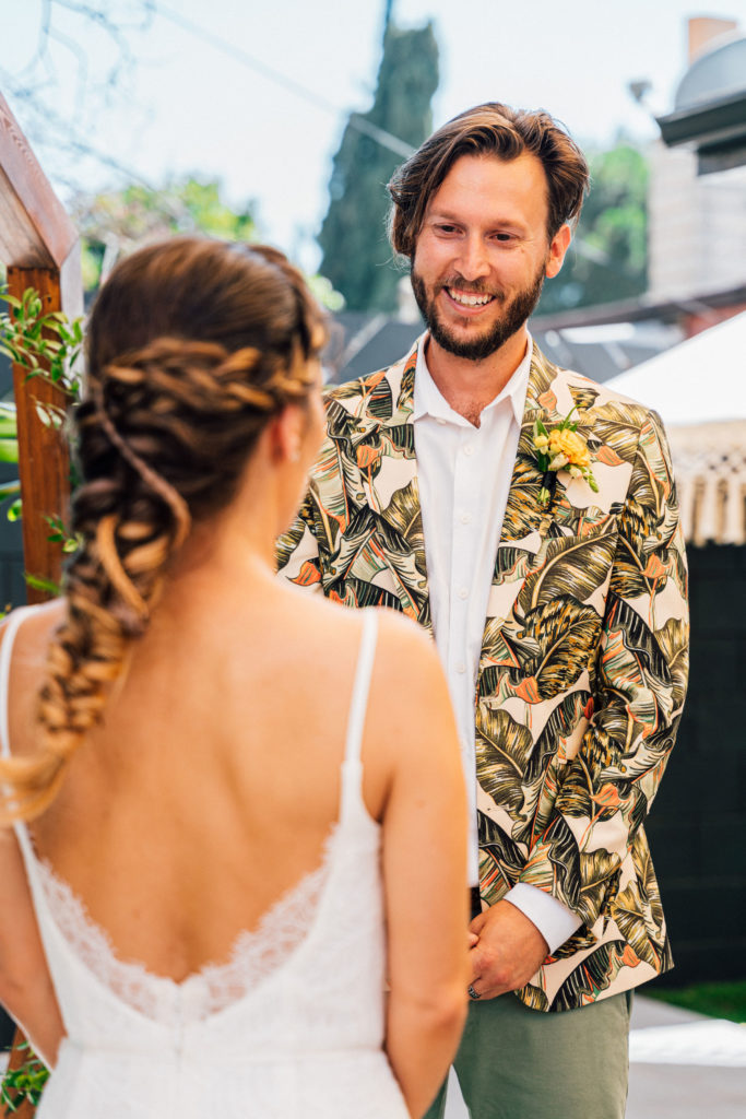 bride and groom backyard wedding ceremony in front of tiki bar