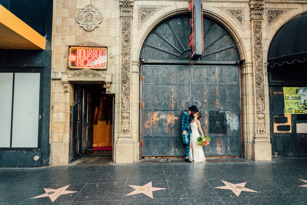 bride and groom kiss in front of the Bourbon Room in Hollywood