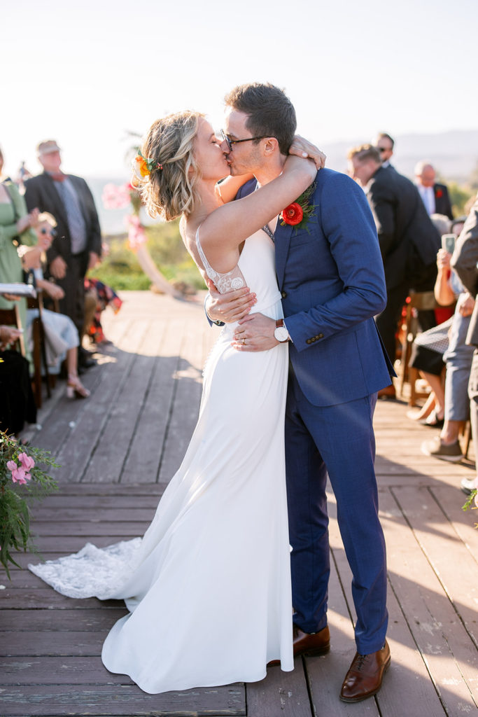 bride and groom first kiss during wedding ceremony at Dos Pueblos Orchid Farm