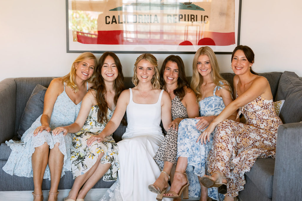 bride poses with friends while getting ready