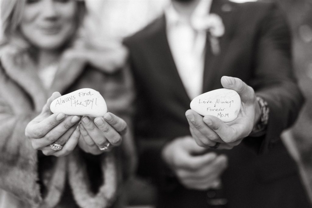 bride and groom hold stones with good luck messages on them for wedding