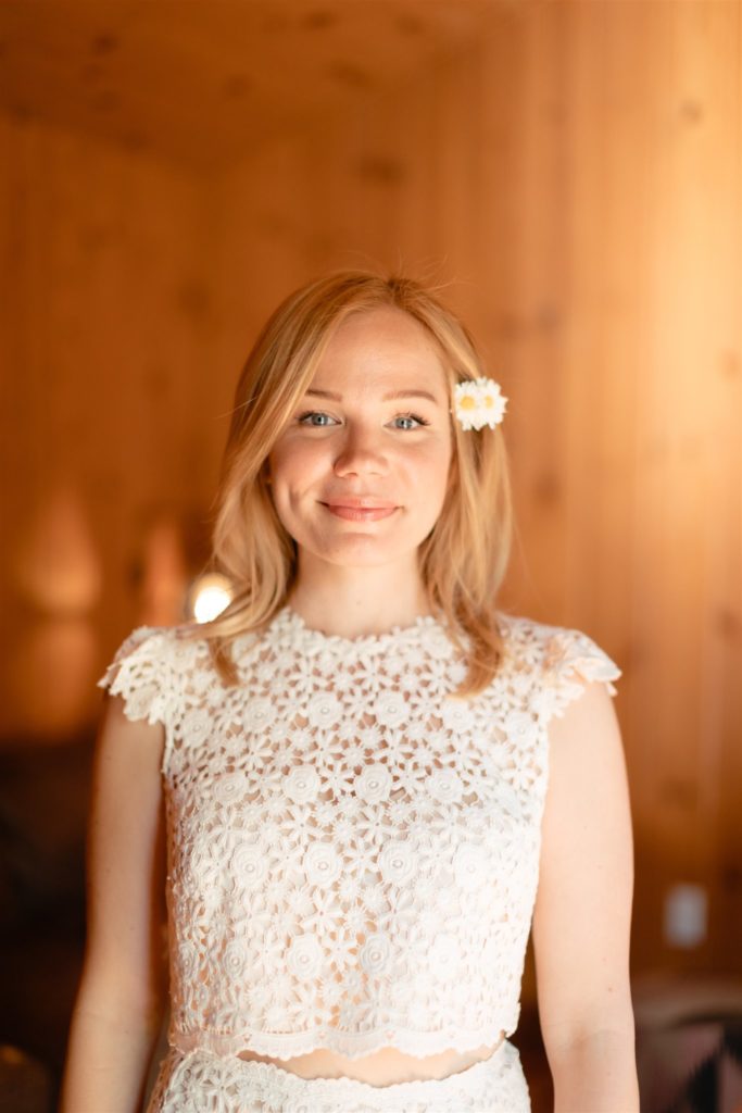 bride wearing two piece wedding dress and a daisy in her hair