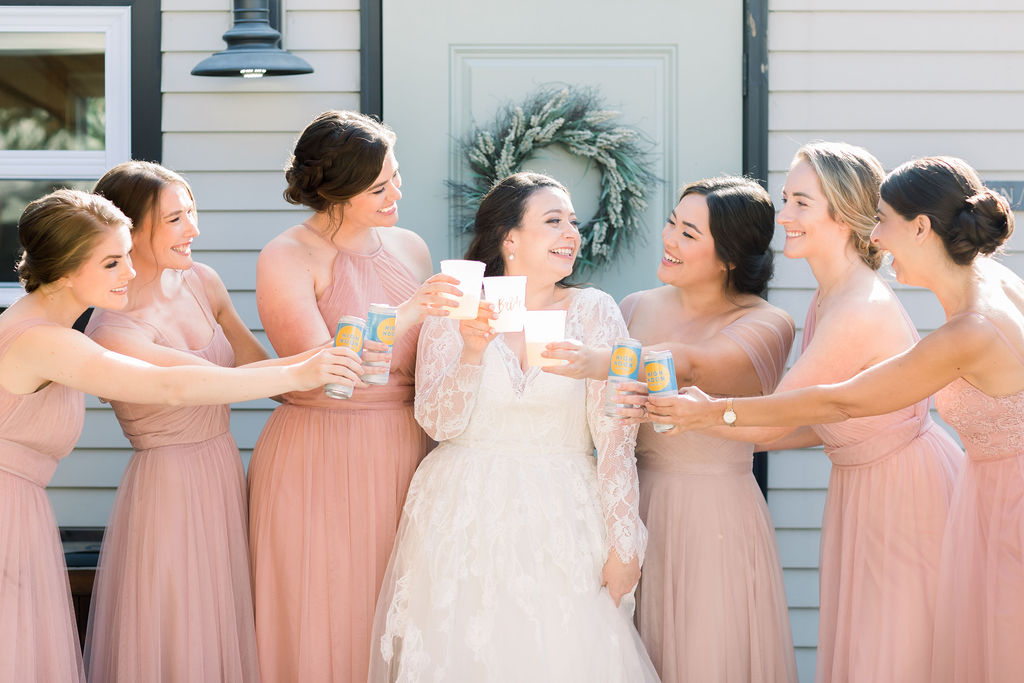 bride and bridesmaids in pink dresses cheers