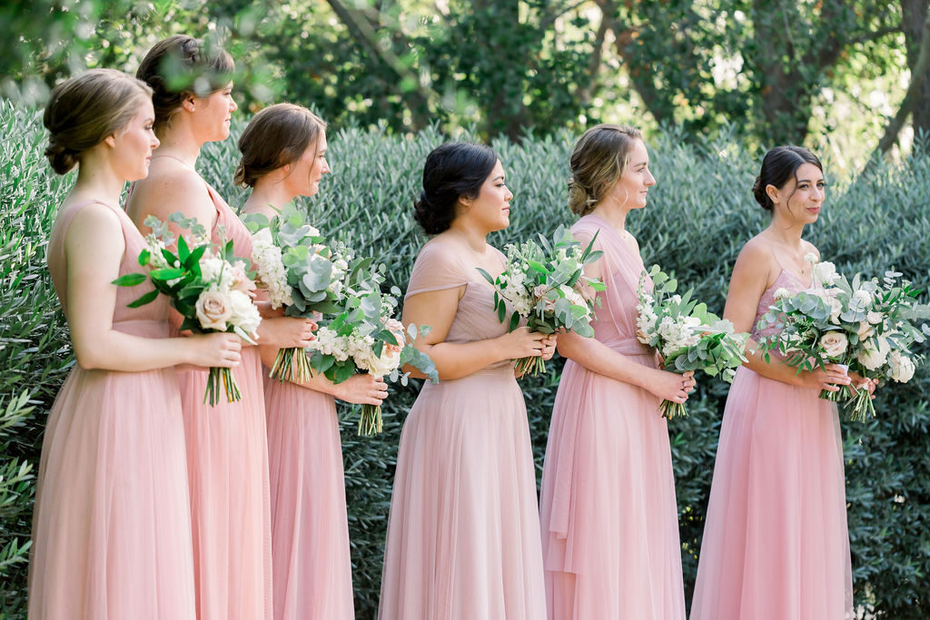 bridesmaids in soft pink dresses during wedding ceremony