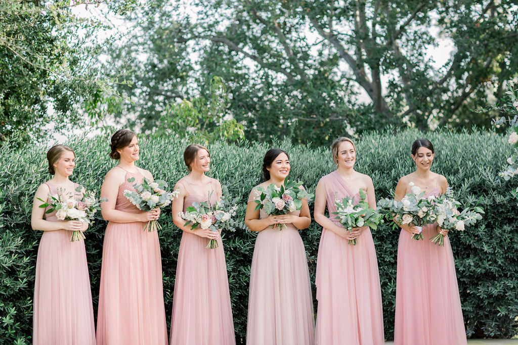 bridesmaids in soft pink dresses during wedding ceremony