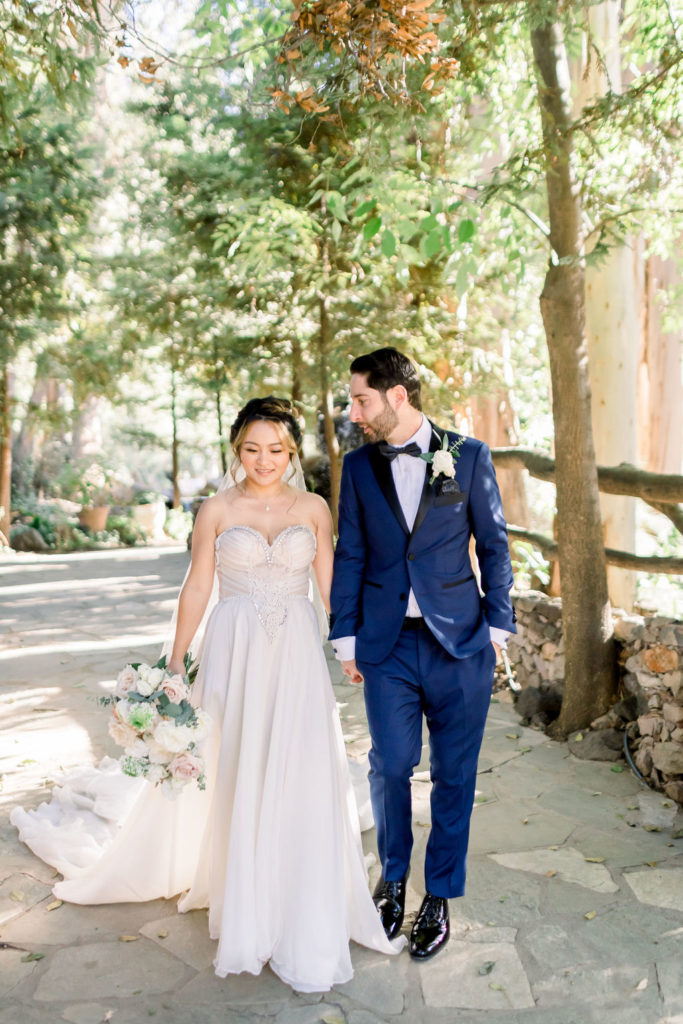 bride wearing beaded sweetheart neckline strapless wedding dress with groom wearing blue suit and black bow tie