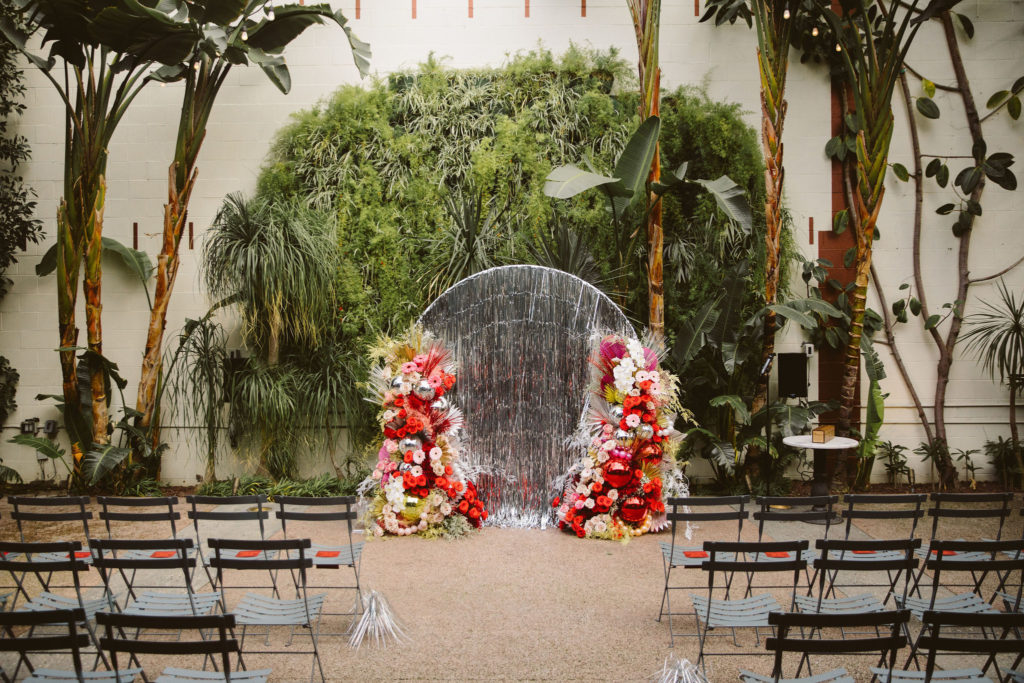silver tinsel wedding circle with pink and red floral arches with disco balls