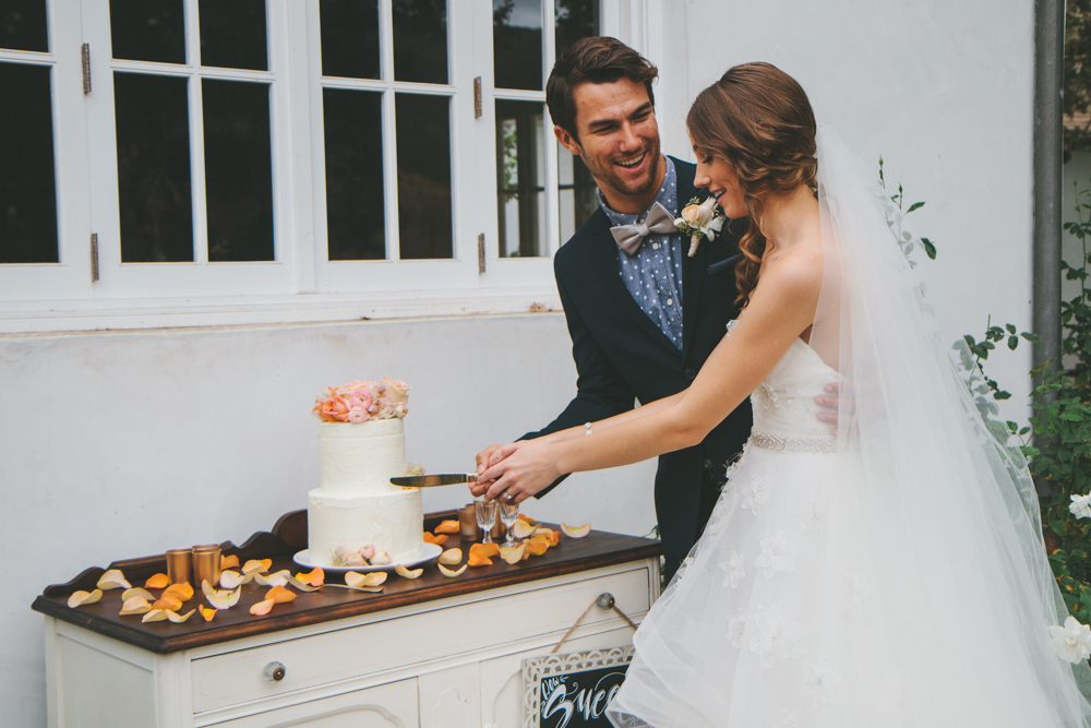 Rustic elegant styled wedding shoot, bride and groom cutting cake