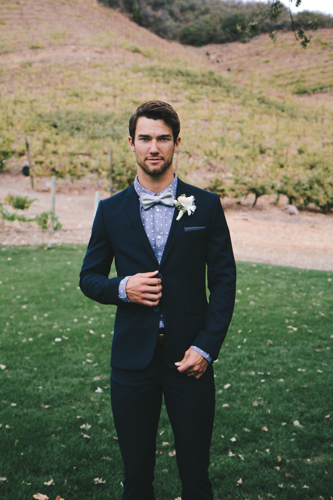 Rustic elegant styled wedding shoot, groom wearing dark navy suit with bowtie