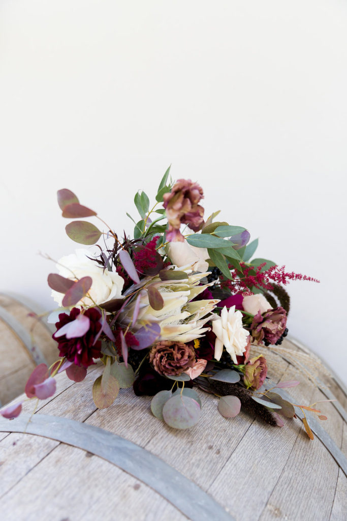 Boho wedding flowers and bouquet with protea and burgundy florals