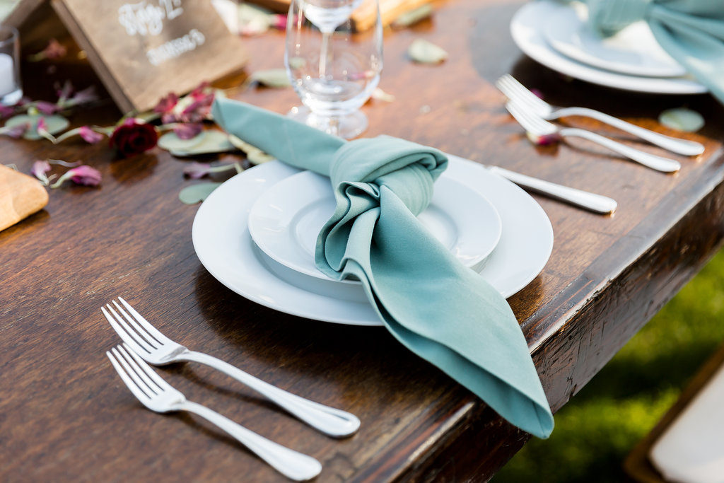 green knotted napkin fold for a wedding reception