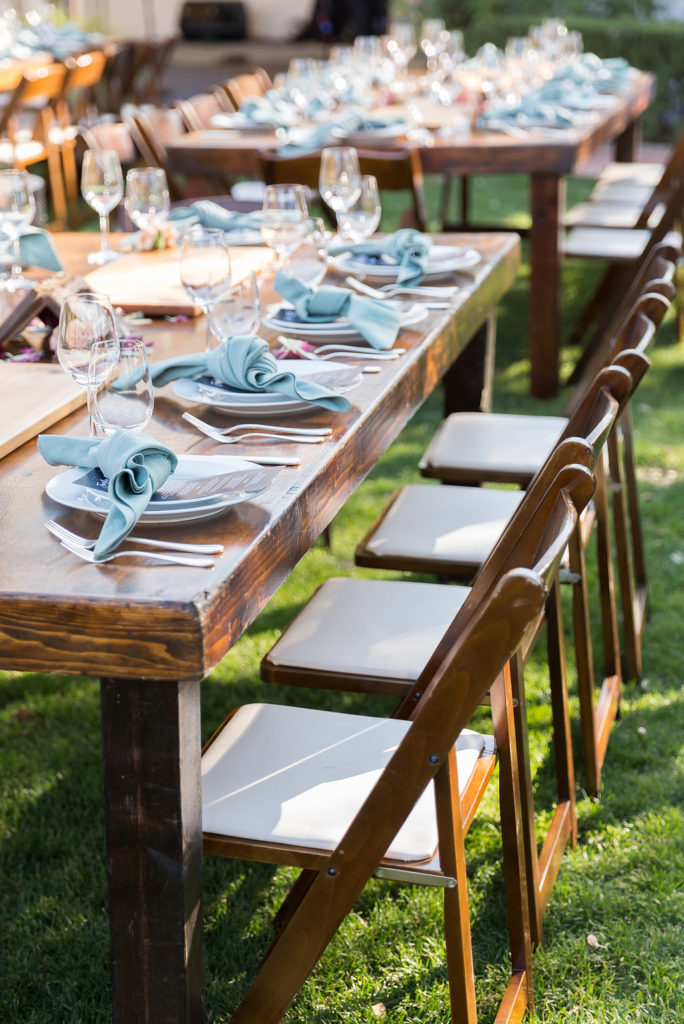Wedding reception with wooden farm tables and fruitwood folding chairs