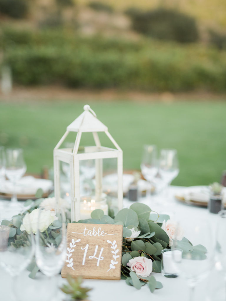 Triunfo creek vineyard wedding reception tables, place setting, lantern centerpiece, white calligraphy, table number