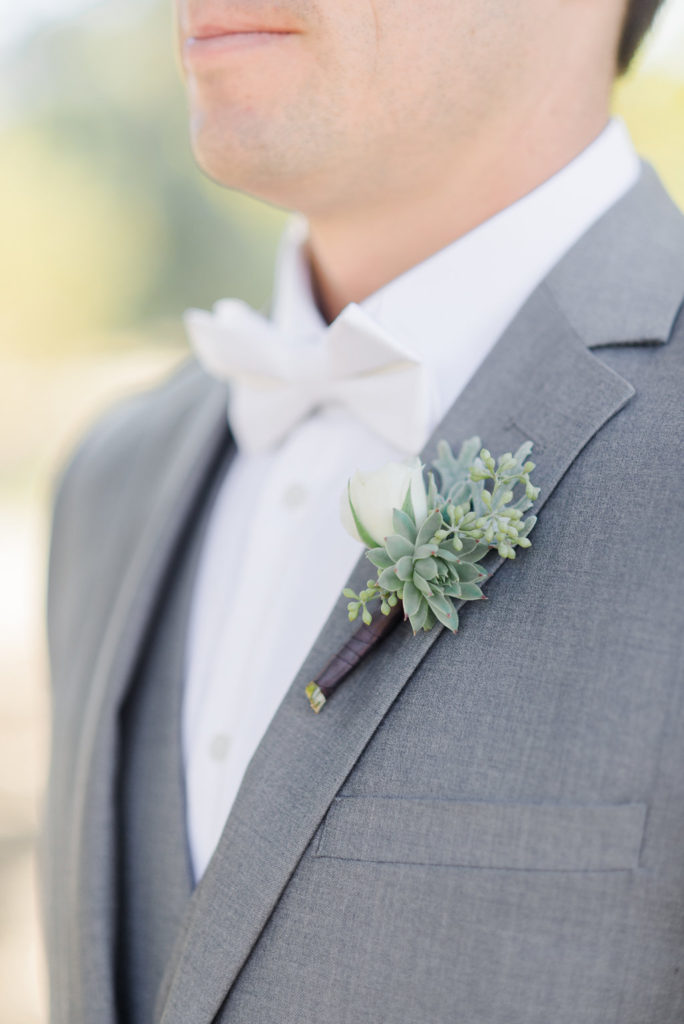 white bowtie, grey groomsmen suit, white spray rose boutonniere