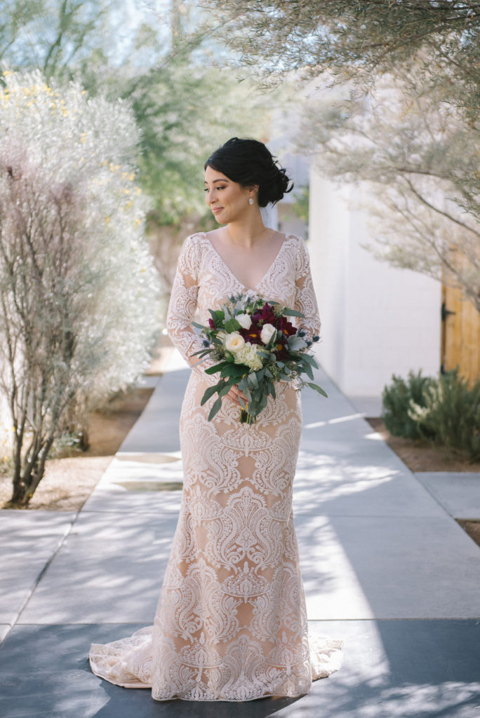 Ace Hotel wedding in Palm Springs bride portrait shot holding red, white and green desert inspired bouquet