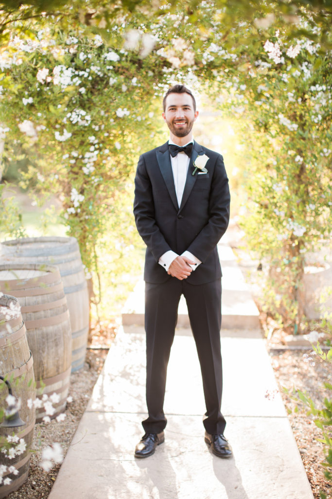 Sogno del fiore wedding in Santa Ynez winery, bride and groom portraits, groom wearing black tuxedo with single rose boutonniere