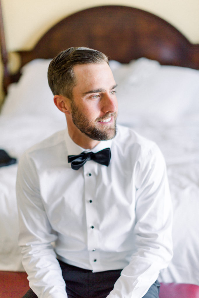 Maravilla Gardens Wedding, groom getting ready with black bowtie and suit from black tux